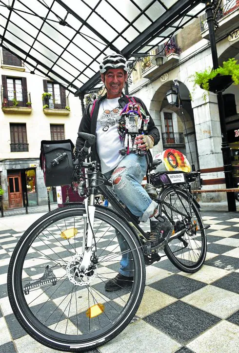 Peio Arruabarrena, con su inseparable Sirimiri y la bici con la que ha recorrido mundo. 