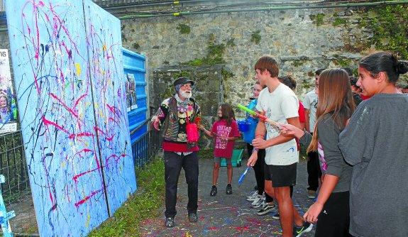 Mural. Juan Gorriti invita a los alumnos a lanzar contra el lienzo los chorros de pintura de sus brochas.