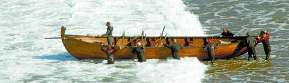 Los remeros de la Telmo Deun, con la barcaza en la playa de Itzurun. 