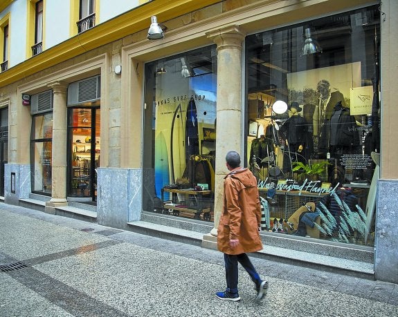 Una persona camina junto al escaparate de Pukas en San Sebastián, que hará descuentos. 