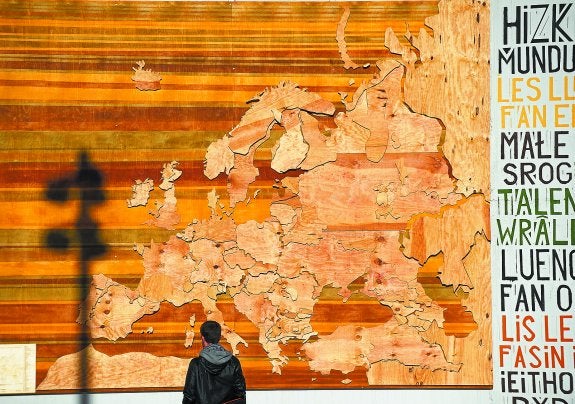 Un viandante observa el mapa de las lenguas de Europa instalado junto al edificio de Tabakalera.