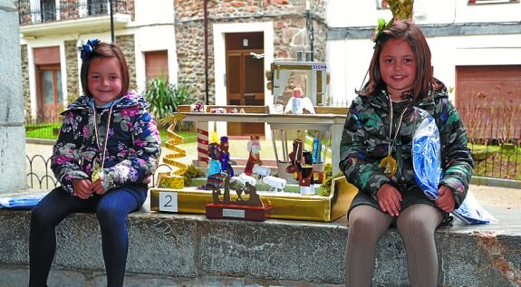 Foto de grupo. Los pequeños belenistas, posando con los organizadores delante del retablo de la parroquia de San Bartolomé.