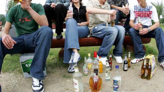 Jóvenes bebiendo alcohol en un parque. 