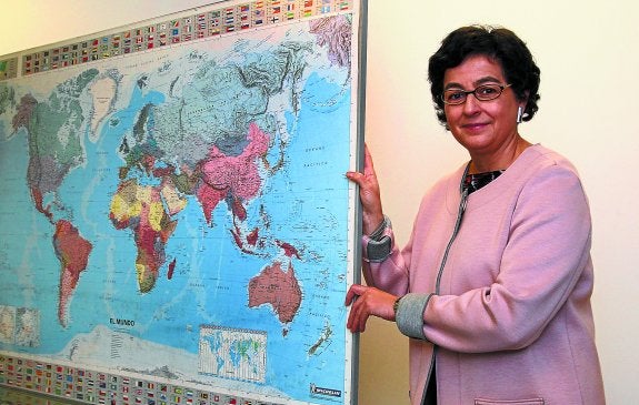 González Laya, experta en comercio internacional, primero en la UE y ahora en la ONU, sostiene un mapamundi.