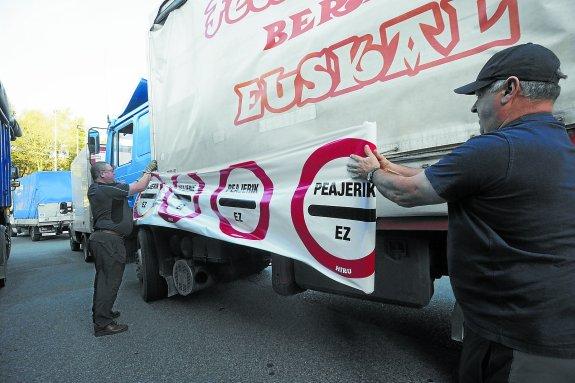 Camioneros colocan carteles durante una protesta contra los peajes.