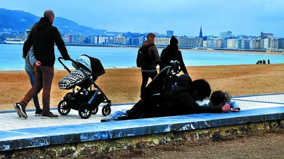 Una familia pasea por Ondarreta, en Donostia. El Gobierno Vasco mantiene este año el presupuesto para las ayudas a la conciliación a las que destinarán 32,5 millones.