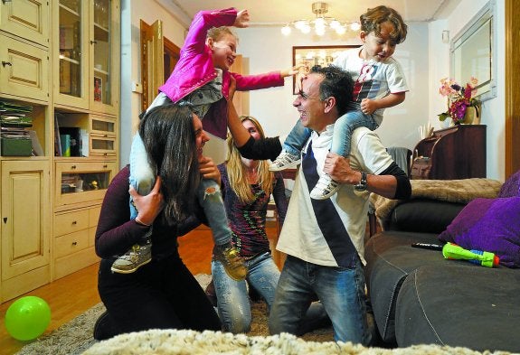 Marcos Chamadoira juega con sus hijos Paola -la mayor-, Lucía y Marcos. Al fondo, su mujer, Carolina.
