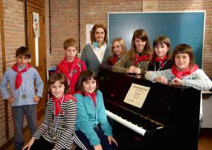Los ocho niños que participaron en el Piano Jaialdia posan con sus medallas junto a su profesora. [ARESTI]