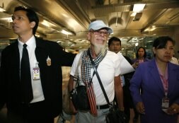 Dos policías escoltan a Gary Glitter en el aeropuerto de Bangkok /REUTERS