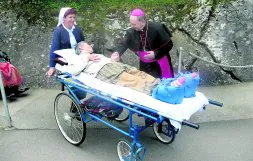 El obispo de San Sebastián, Juan María Uriarte, conversa con una enferma en Lourdes.