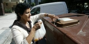Una mujer deposita restos de alimentos frescos en un contenedor del barrio donostiarra de Amara. Cada vecino tiene una llave para abrir el container. /LUSA