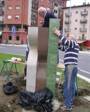 Dos hombres colocan la escultura en el cruce de Zaldizurreta.
