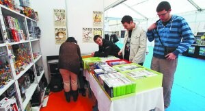 Para todos los gustos. Tres visitantes del salón del cómics en uno de los stands con videojuegos, posters, figuras... ::
F. DE LA HERA