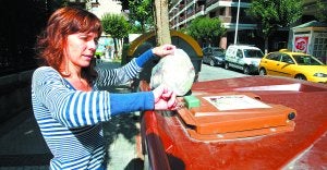 Una mujer abre con su llave el contenedor destinado a restos de comida, situado en el barrio donostiarra de Amara. ::
MIKEL FRAILE