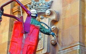 Un operario de FCC limpia la fachada del Ayuntamiento. ::
MICHELENA
