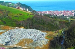 Vertedero. Un gran montículo, con toda la basura a la vista, y al fondo Zarautz. Los vecinos piden que se tape. ::                             ETXEBERRIA