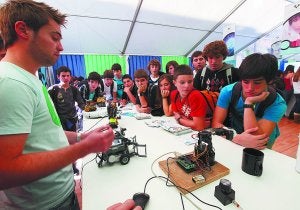 Robótica. Unos estudiantes observan con curiosidad las 'tripas' del robot en uno de los stands. ::                             LUSA