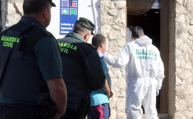 La guardia civil conduce al hombre que se salvó del tiroteo. 