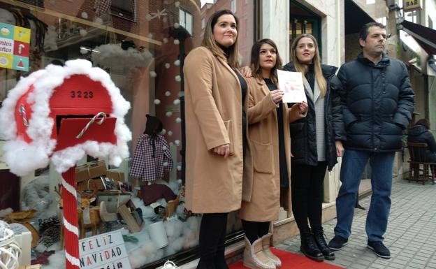 La concejala de Comercio, Lorena Valle (2I) y el vicepresidente de la Cámara de Comercio de León, Javier Morán, entregan el premio a las propietarias de La Tata.