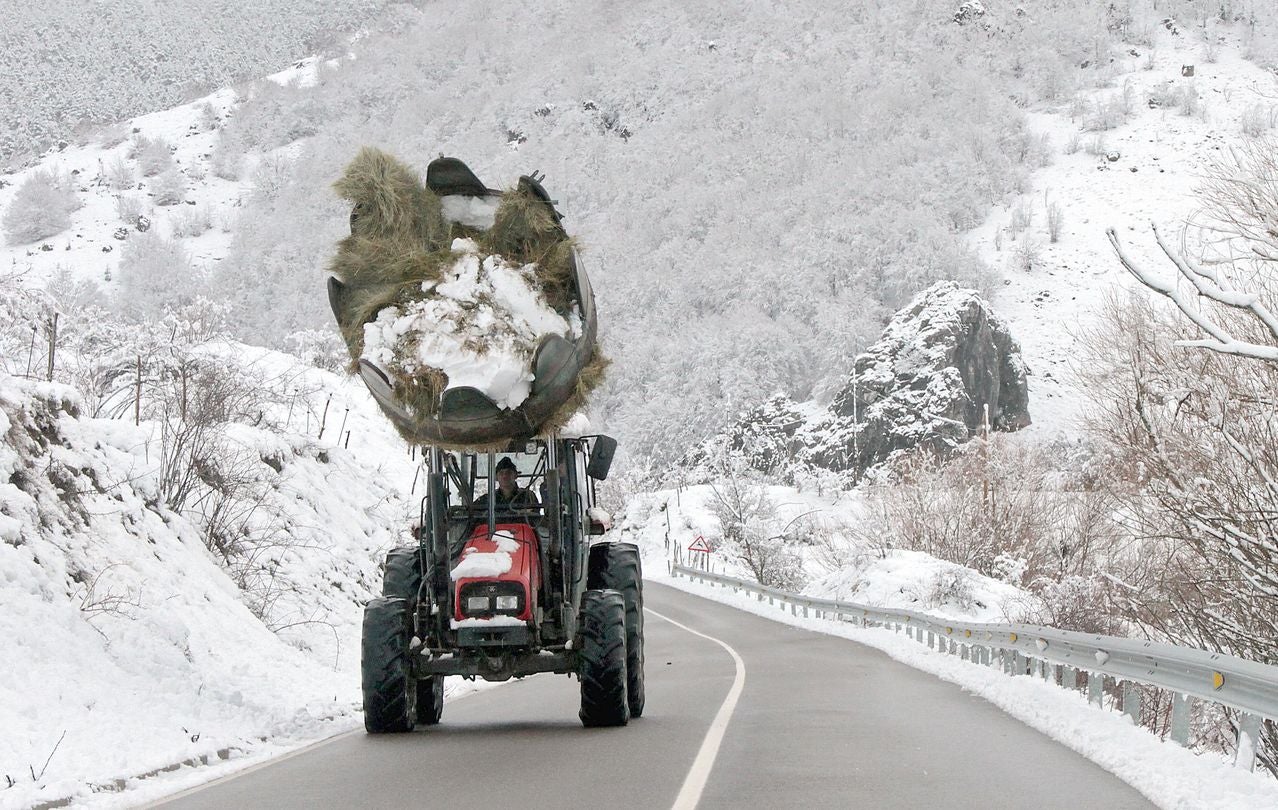 Un tractor transita por una zona nevada de la montaña de León.