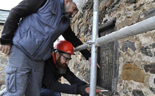 Los restauradores Carlos Ávila de la Torre y Francisco Boldo Pascua aplican tratamientos de protección sobre los escudos del Castillo Viejo.