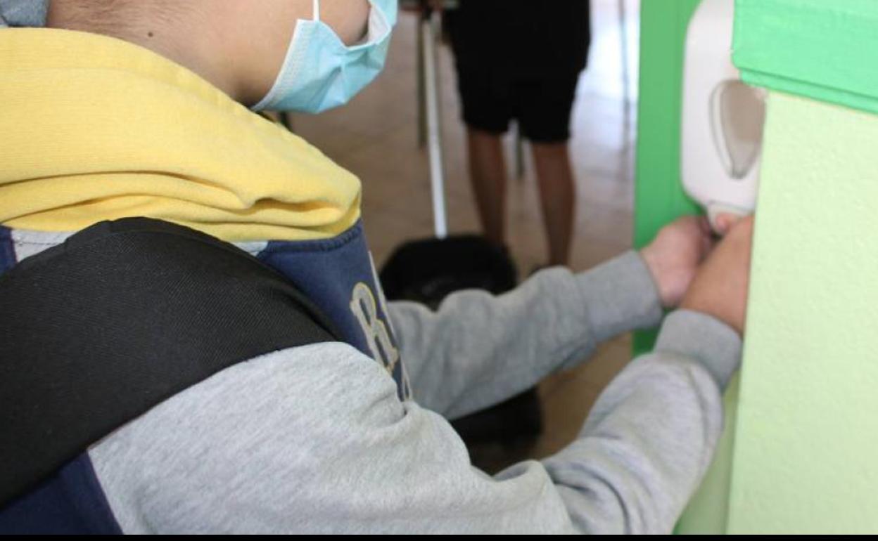 Un escolar se desinfecta las manos con gel hidroalcohólico.
