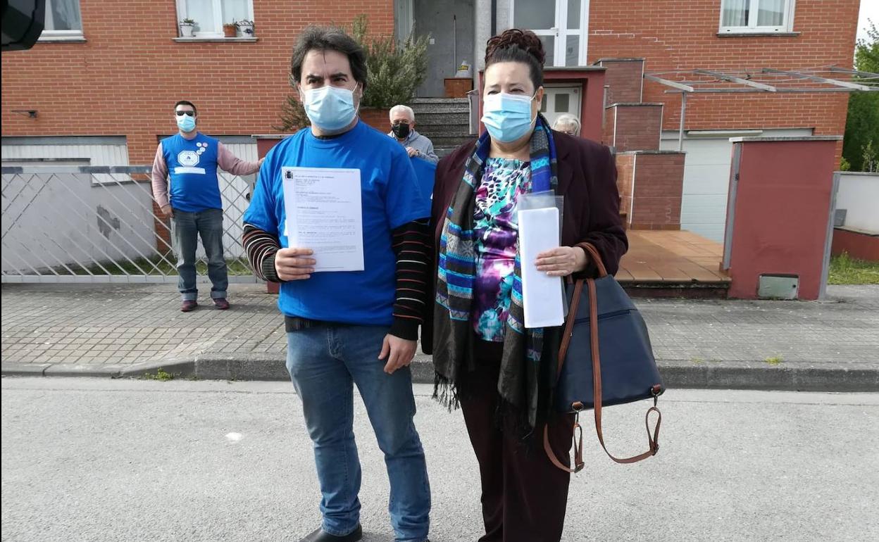 La presidenta y el vicepresidente de la PAH Bierzo muestran la diligencia de alzamiento del desahucio. 