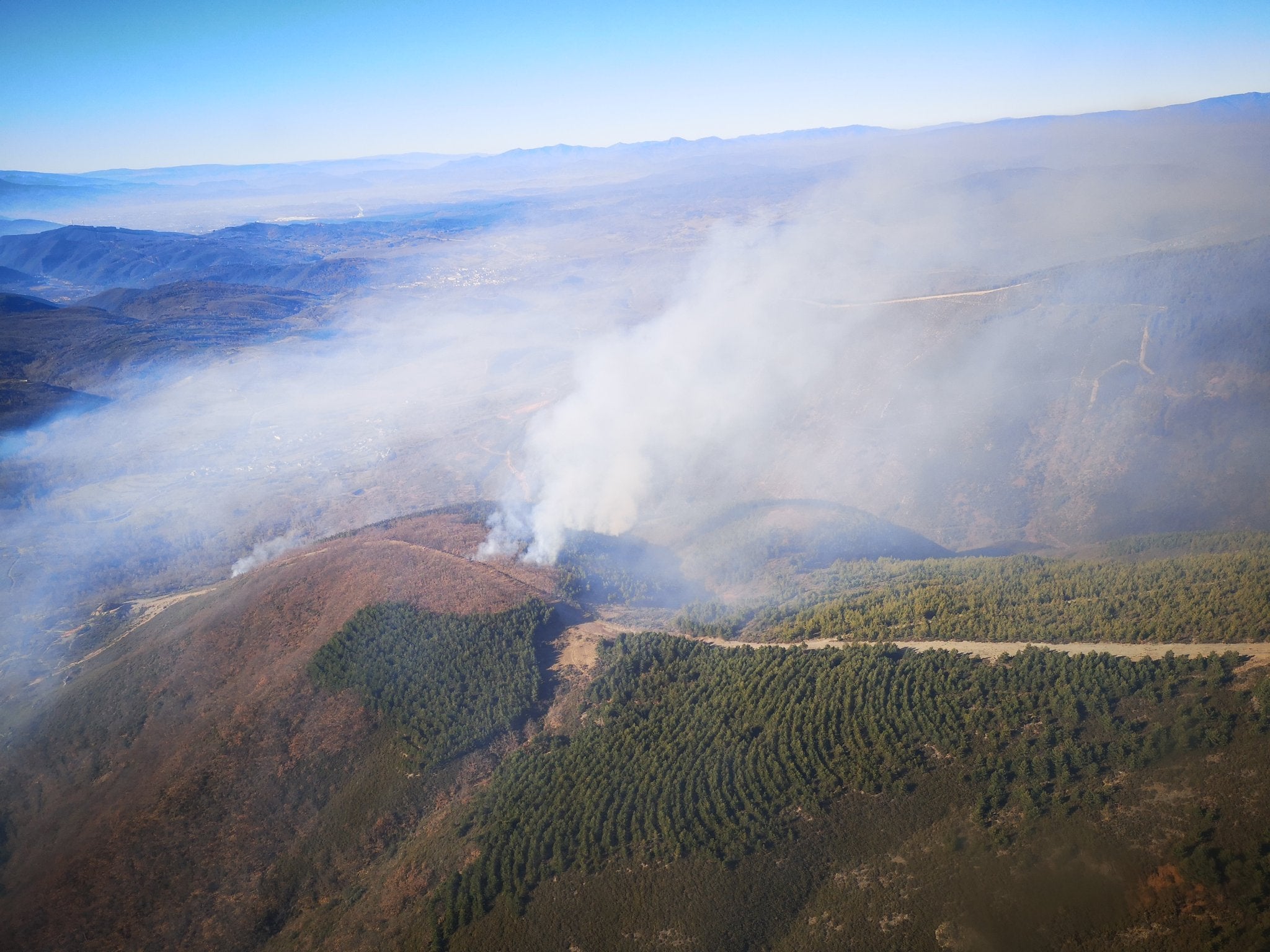 Varios brigadistas y helicópteros trabajan en la extinción de un incendio decretado este martes.