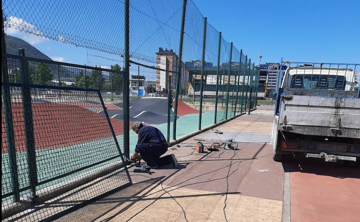 Los operarios de la Brigada Municipal de Obras reparan el cierre perimetral de la pista de pumptrack en el Complejo Deportivo Lydia Valentín.