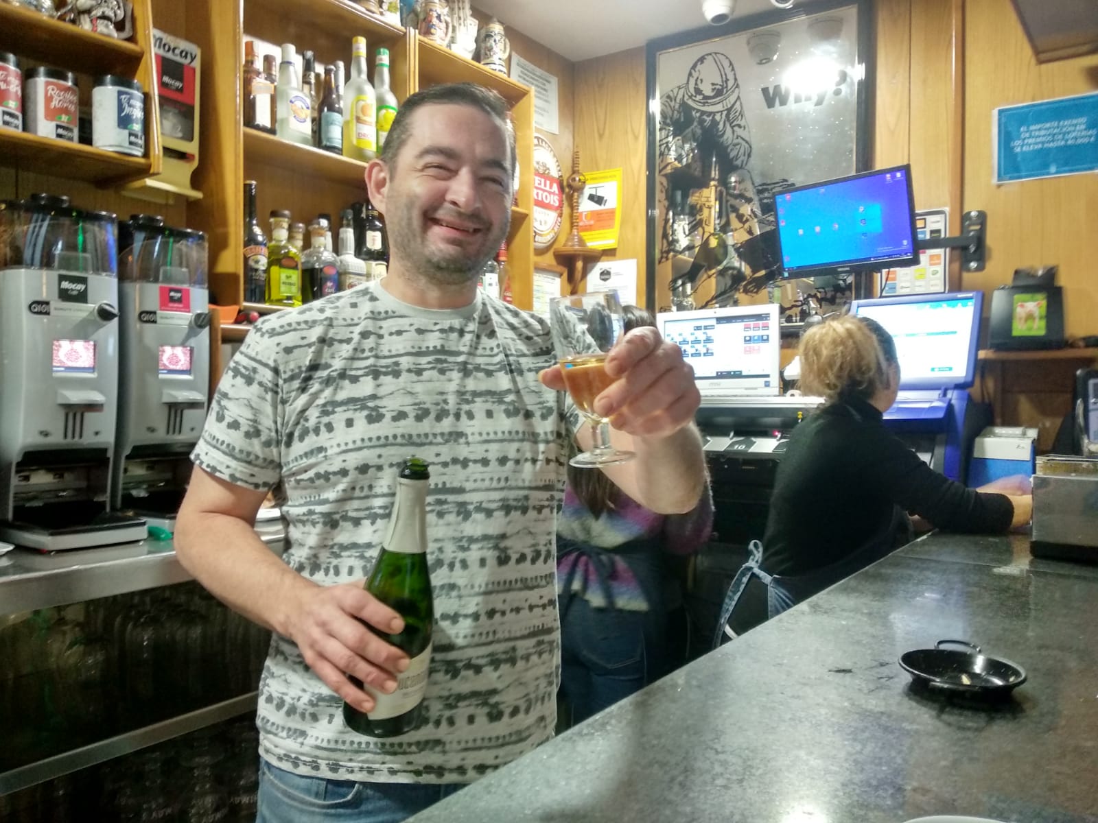 El propietario del bar Moderno celebra el premio repartido, el Gordo de la Navida, desde su establecimiento.