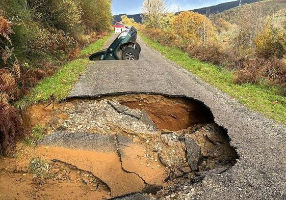 Imagen de los socavones que se tragaron dos coches en la carretera del pueblo berciano de La Cernada.