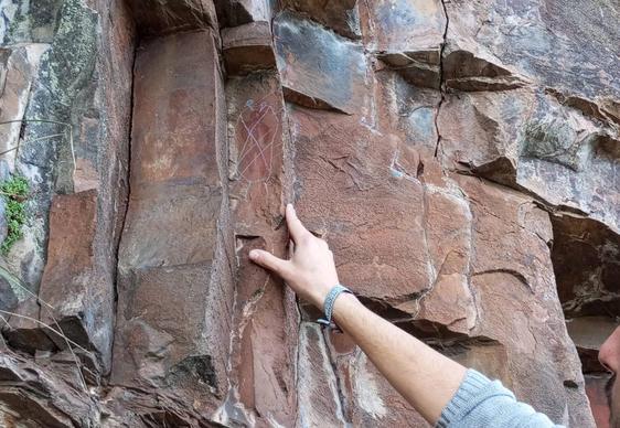 El concejal de Cultura de Vega de Espinareda, Pablo Taladrid, señala los daños provocados en las pinturas rupestres de Peña Piñera.