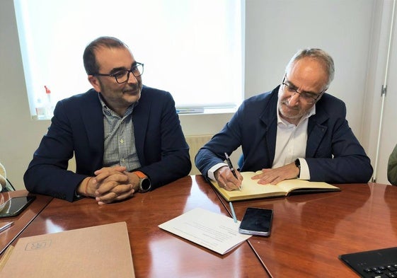 El presidente del Consejo junto al alcalde de Cubillos del Sil, firmando en el libro de honor del Ayuntamiento.