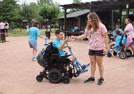 Uno de los niños que están en el campamento de Aspaym junto con una de las monitoras.