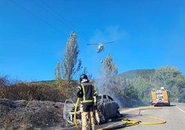 Los Bomberos de Ponferrada sofocando las llamas del vehículo.