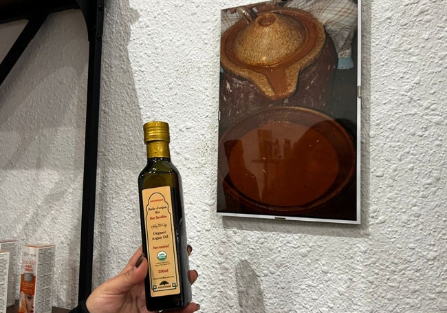 Aceite de argán y una imagen de su proceso de elaboración que se expone en Maison Elixir