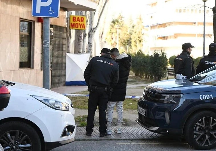 Un agente de la Policía Nacional junto al cuerpo de un hombre de unos 60 años, que ha aparecido muerto en la mañana de este lunes con heridas de arma de fuego.