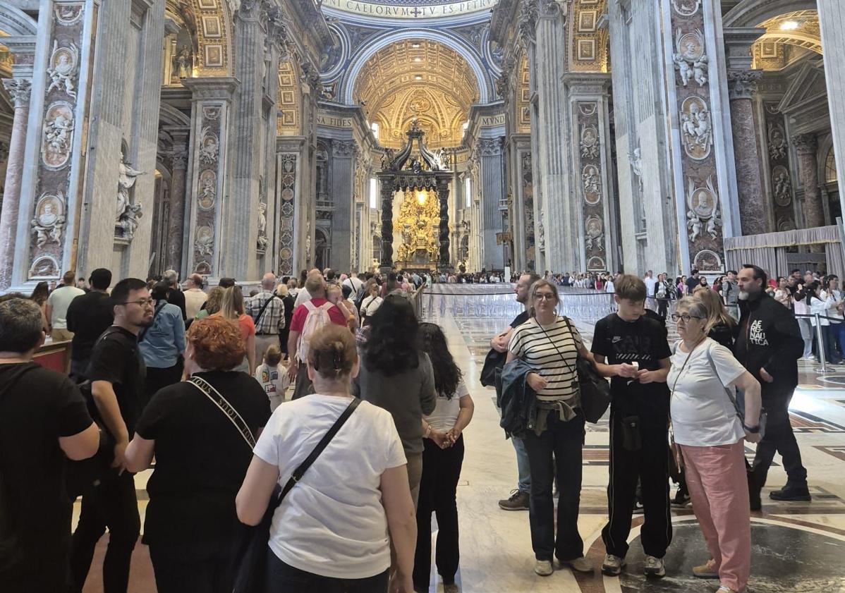 Imagen principal - La periodista berciana junto a su familia en la Basílica de San Pedro (arriba); multitud de periodista agolpados en la plaza de San Pedro (centro) y ramos de flores ante el Vaticano (abajo).