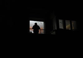 Un vecino de Ponferrada se asoma a la ventana y observa la calle en completa oscuridad