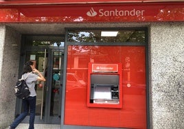 Una joven a las puertas de la oficina del Banco Santander en la calle Ancha de Ponferrada.
