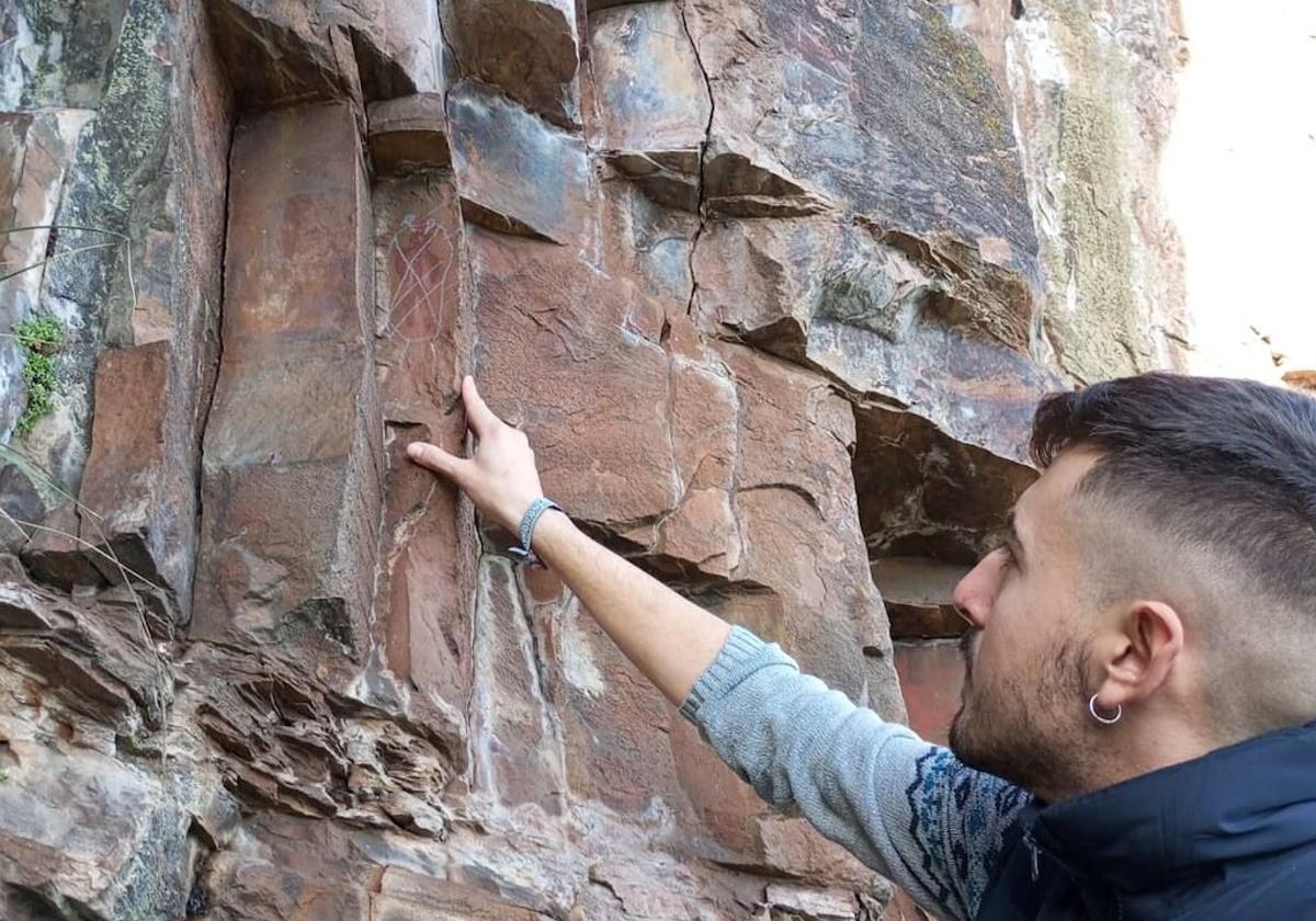 El concejal de Turismo de Vega de Espinareda, Pablo Taladrid, muestra los daños ocasionados en las pinturas rupestres de Sésamo, en una imagen de archivo.