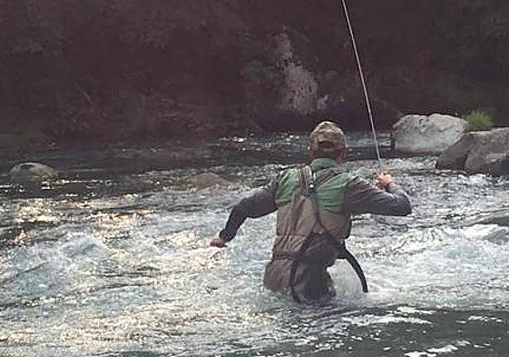 Un pescador en medio de un río en una imagen de archivo.