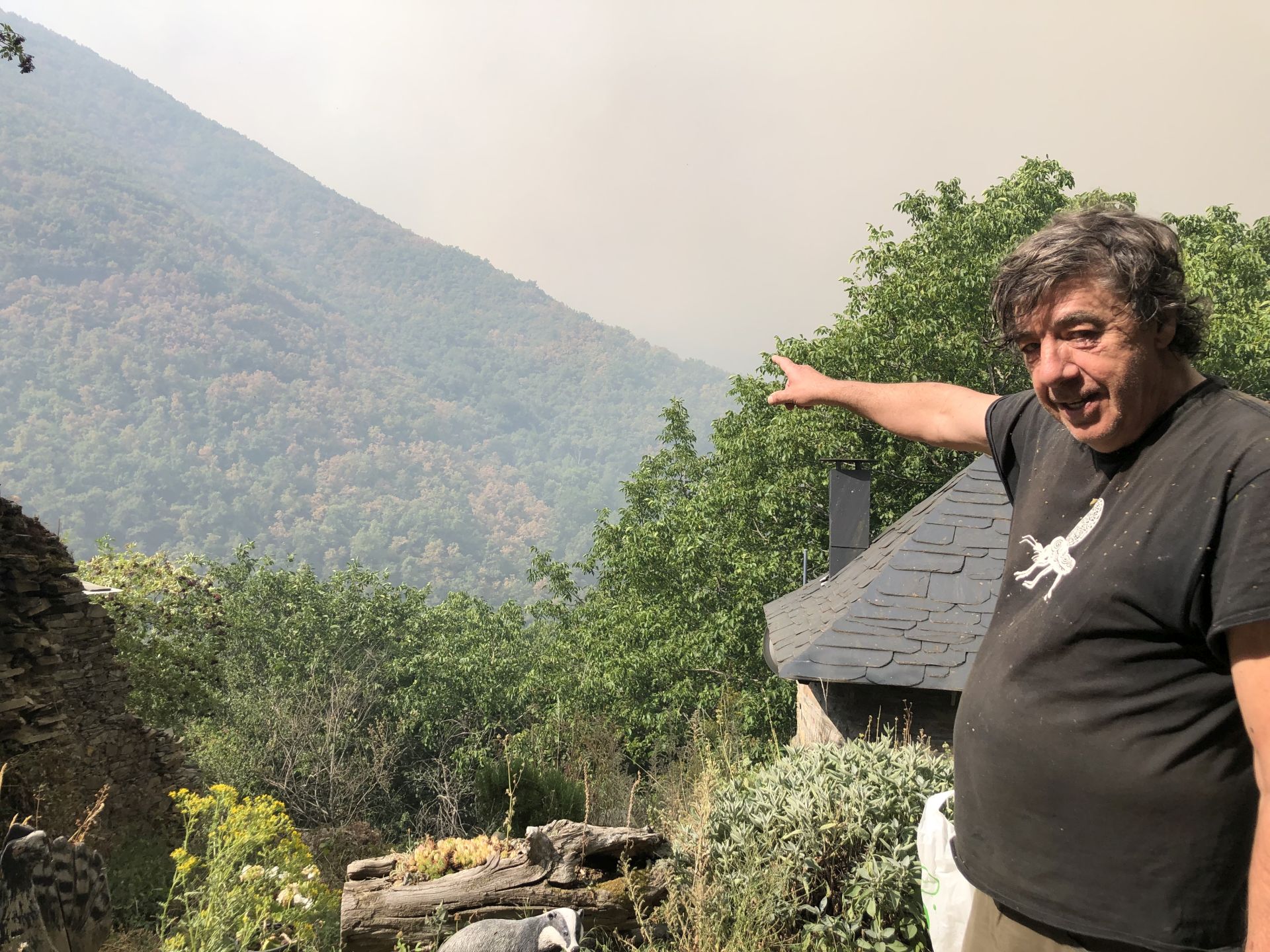 El vecino de Palacios de Compludo, Miguel Gallego, señala hacia el fuego que avanza hacia la reserva ornitológica.