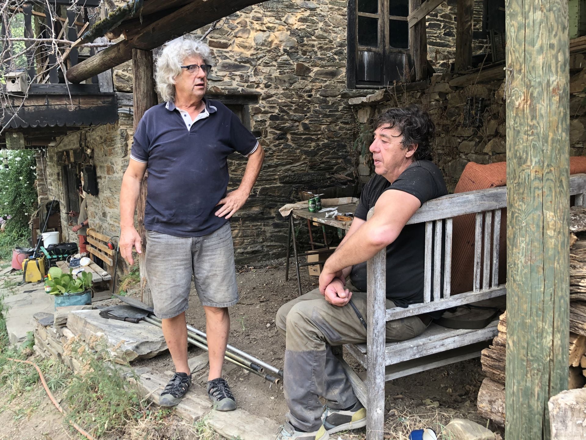 Dos vecinos de Palacios de Compludo conversan a la puerta de una de las casas del pueblo.