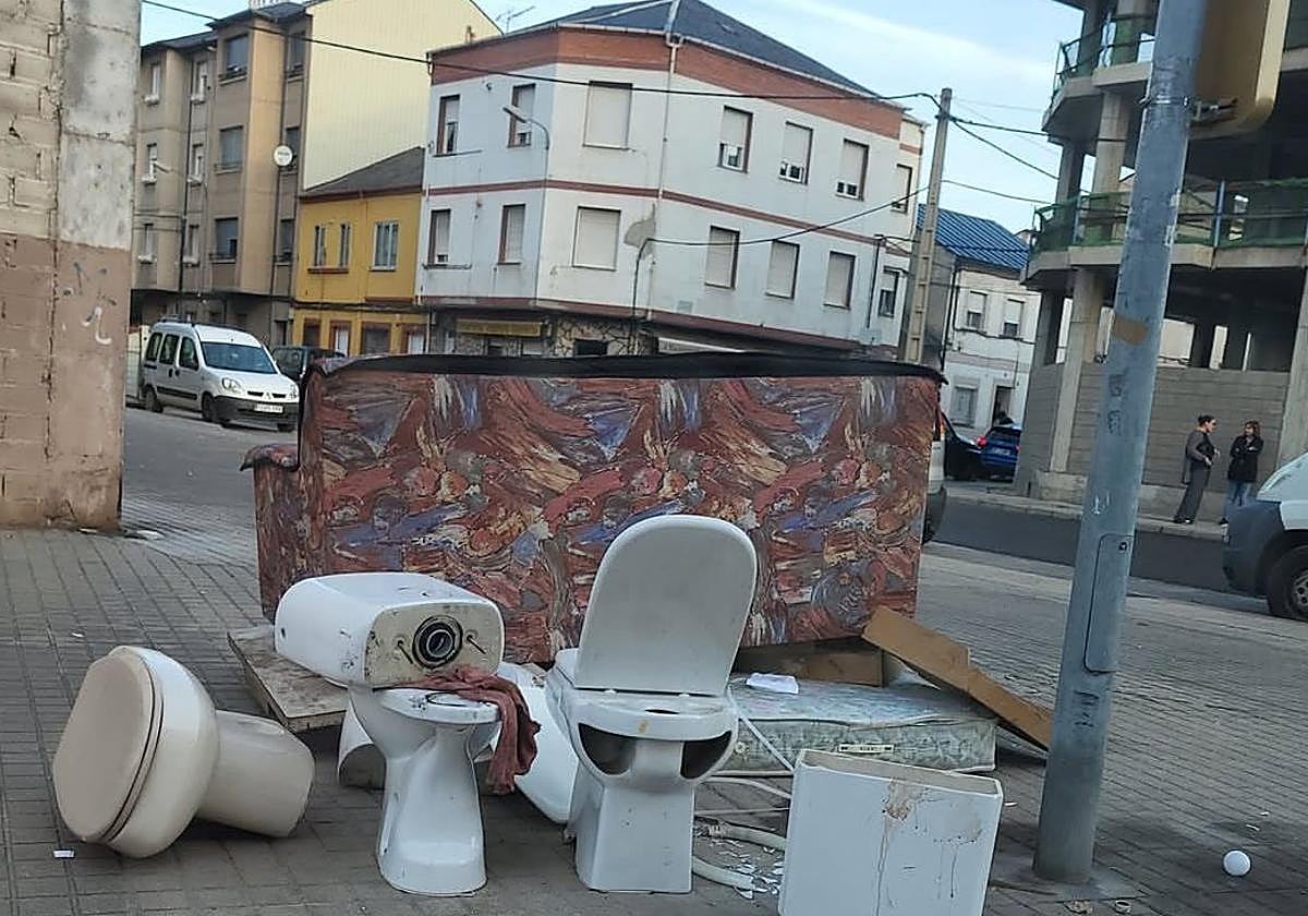 Imagen de varios sanitarios, colchones y un sofá en una calle en el barrio de Cuatrovientos.