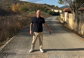 Luciano Arias, presidente de la asociación vecinal Camino del Escaril, señalando el tramo donde acaba el asfaltado y comienza otra vez el camino de tierra.