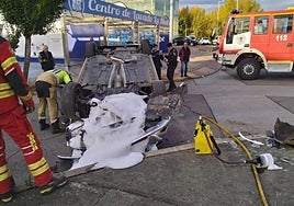 Imagen de los bomberos limpiando la calzada en el lugar del accidente.