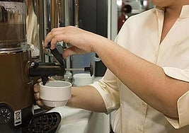 Un camarero sirve un café en un bar.