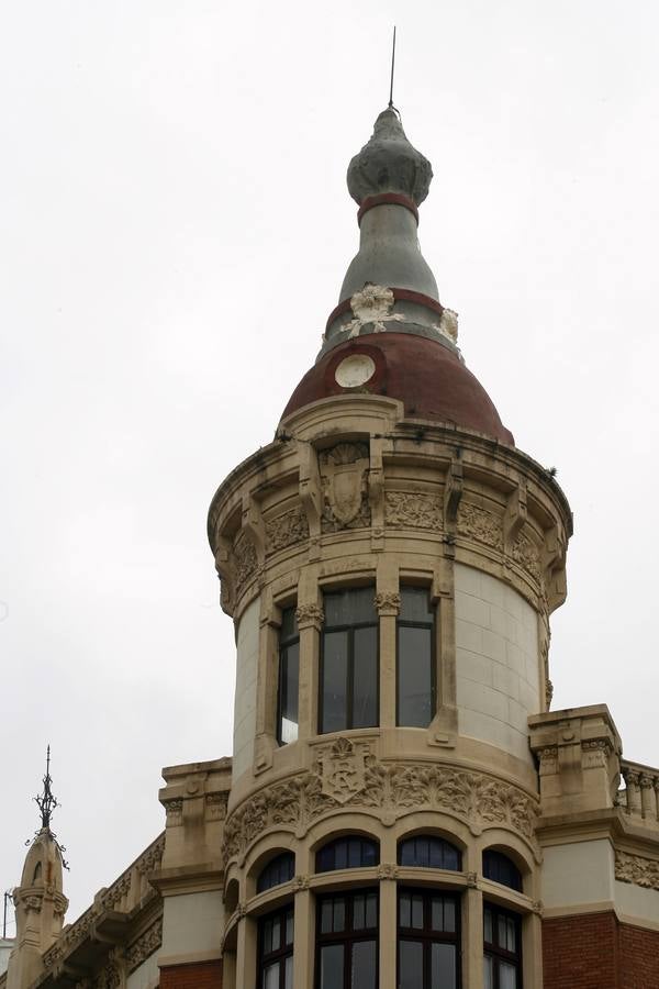 Principado, 5. El edificio en cuyos bajos hoy está una sede de HC, destaca por su torreón, que compite con las ostentosas arquitecturas de su entorno. Antiguamente, la cúpula estaba revestida por una cerámica de colores que era uno de los elementos exóticos de la ciudad. El edificio es obra de Manuel del Busto y data de los años 1908 y 1909