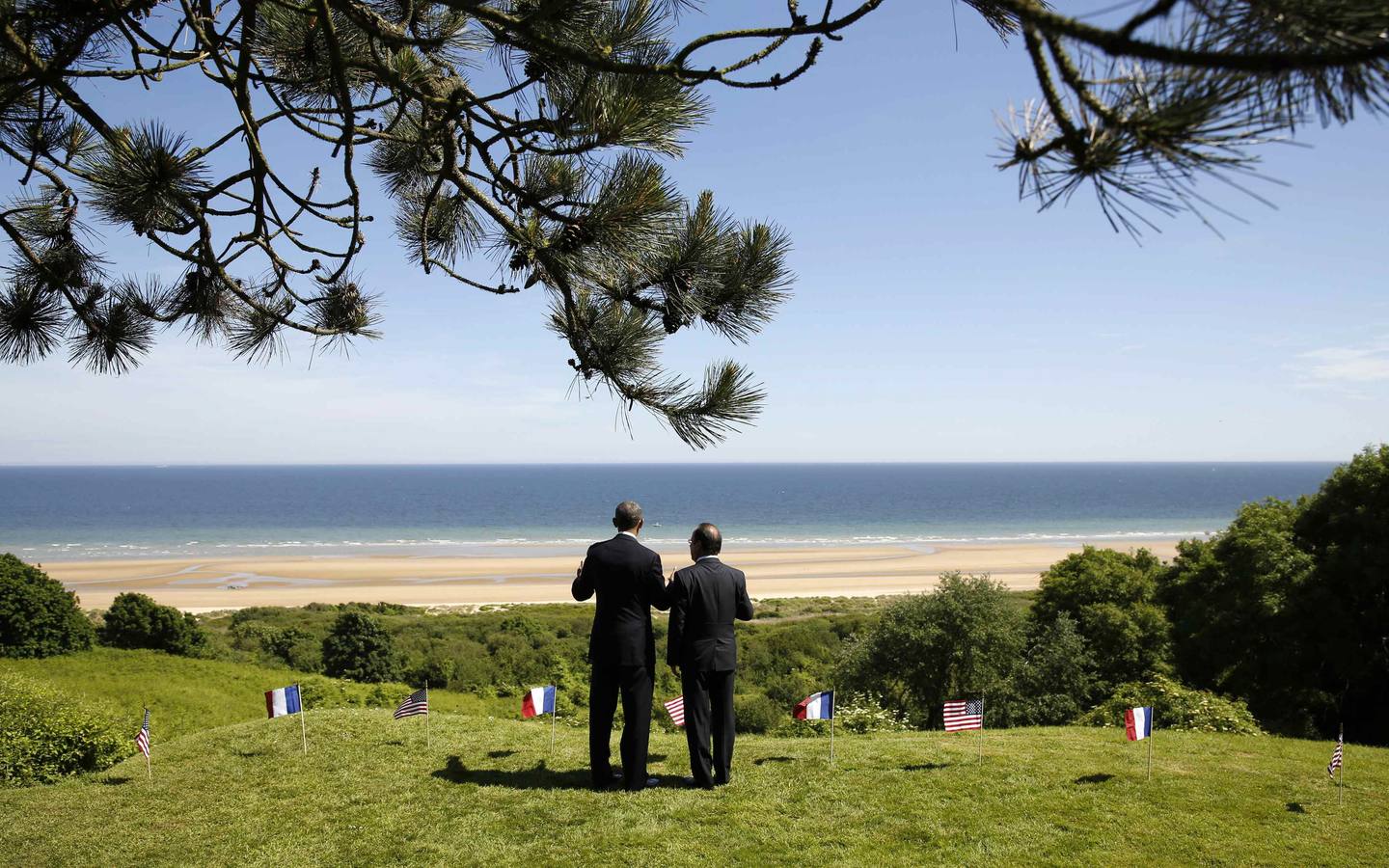 Juntos en el lugar del Día D. Los presidentes de EE UU observan la zona del desembarco de Normandía en la conmemoración del 70 aniversario.